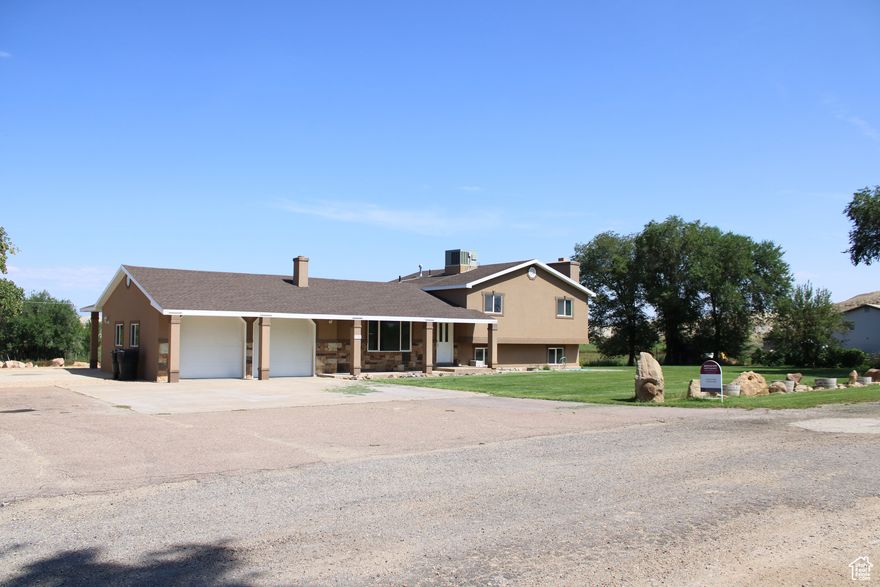 Tucked away on a quiet lane in Myton, this 5.51-acre irrigated horse ranch blends comfort, function, and lifestyle. The spacious 2,928 sq ft four-level home offers 3 bedrooms, 2.5 baths, two expansive family rooms, and a craft or office space that could also serve as a fourth bedroom. The kitchen has been updated with new cabinetry, and both the roof and stucco are only 6 years old, giving the home lasting curb appeal.  Outdoors, nearly 3 acres of irrigated pasture create a lush setting for horses or livestock. The property includes a colossal 7,800 sq ft equipment shed with room for horse stalls, hay storage, RVs, or farm equipment. A 918 sq ft commercial-grade workshop with 220V power, bright lighting, and a brand-new roof offers endless possibilities for projects and storage. Dedicated RV hookups and a septic system add convenience, while additional sheds across the property provide extra utility.  Every detail has been designed for a true ranch lifestyle. Picture horses grazing in the pastures, projects coming to life in the shop, and evenings spent under wide-open skies. Properties like this are rare, a turnkey retreat ready for you to step in and make your own.