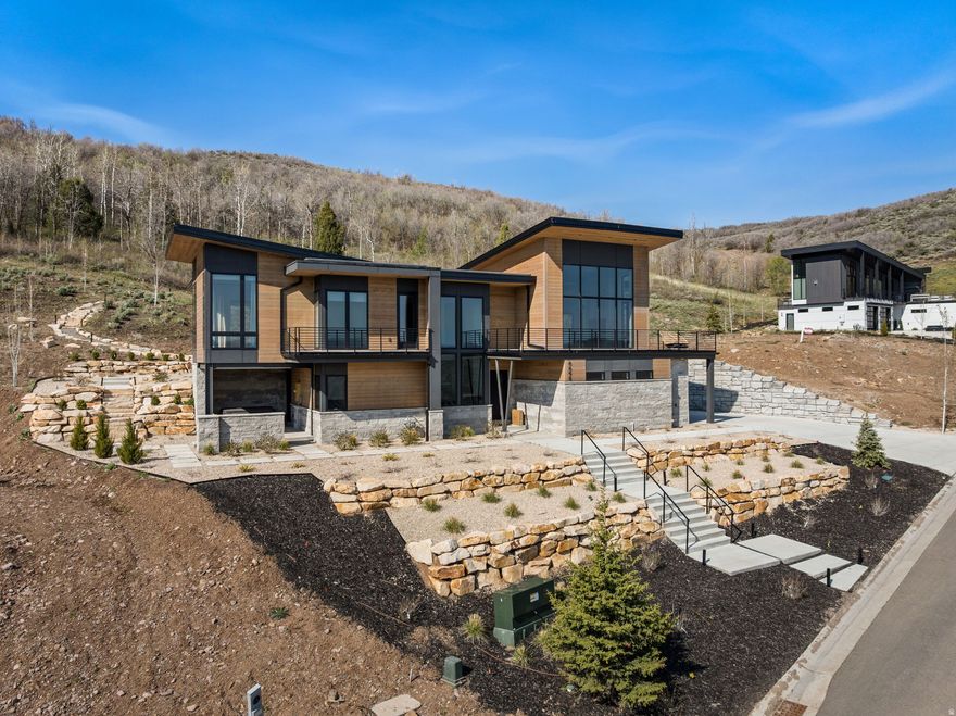 Nestled in the mountains on nearly an acre, this stunning mountain modern custom home offers the perfect blend of luxury, privacy, and serenity. Surrounded by mature trees, abundant wildlife, and breathtaking natural beauty, this property feels like a private retreat with no back neighbors and peaceful mountain views in every direction. Extensive custom landscaping has transformed the property into a true mountain oasis, complete with a private trail leading up the mountainside to a secluded fire pit-perfect for taking in sunsets, stargazing, and enjoying the peaceful surroundings. Thoughtfully designed with high-end finishes, expansive windows, and seamless indoor-outdoor living, the home captures the essence of elevated mountain living. Enjoy the tranquility of nature while being just minutes from Park City, Deer Valley, and world-class skiing, dining, shopping, and year-round recreation. A rare opportunity to own a luxury mountain escape with unmatched privacy and convenience.
