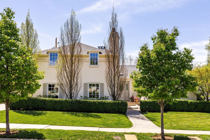 Located along a charming street in Salt Lake City's Country Club neighborhood, this exceptional two-story residence sits on a beautifully sized .25-acre parcel, offering a thoughtful blend of space, character and modern updates. Upon entry, the home's interior reveals a warm and inviting atmosphere. The front sitting room is filled with natural light and features large windows, custom built-in cabinetry and a gas fireplace. The main level flows seamlessly into a kitchen dining area and a newly updated kitchen appointed with custom cherry cabinetry and granite countertops. Just beyond, a formal dining and sitting area with a second gas fireplace opens to a covered rear patio, creating an ideal setting for both everyday living and entertaining. This level also includes two bedrooms, one with an ensuite bath, an additional full bathroom, along with a dedicated office featuring custom desk and shelving. Upstairs, the primary suite offers a private retreat complete with a sitting area and fireplace, a three-quarter bath with double vanity, and a spacious walk-in closet. The lower level expands the home's versatility with a large family room featuring built-in cabinetry and bar, an additional family room, laundry area, two bedrooms, and a three-quarter bathroom. Outdoors, the covered patio and expansive side yard provide ample space for recreation, entertaining or quiet relaxation. Located in a highly walkable neighborhood with convenient freeway access, this home presents a rare opportunity to enjoy both comfort and connectivity in one of Salt Lake City's most established settings.
