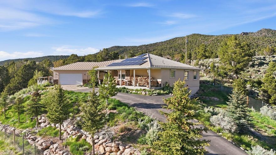 Tucked at the end of a private road in scenic Pine Valley, this one-of-a-kind 1.04-acre property offers unmatched privacy, direct bordering access to Forest Service land, and breathtaking 180-degree views of the Pine Valley mountains and Santa Clara River. Built in 2010, this well-crafted two-level home features 2,622 sq ft on the main level with an additional 1,510 sq ft basement, providing ample space and future potential. Designed with self-sufficiency and rural living in mind, the property includes solar panels with Tesla backup battery storage, a greenhouse, chicken coop, enclosed garden area with raised beds, and a variety of fruit trees. The property is fully fenced, offering flexibility for animals and outdoor use. Inside, you'll find a warm and inviting layout highlighted by a beautiful sunroom, a cozy wood-burning stove, and large windows that capture the incredible surrounding views. The unfinished basement includes garage door access and is spacious enough to accommodate a side-by-side, offering flexibility for storage, recreation, or future expansion. Exterior features include durable stucco siding, a metal roof, and roll-down metal security blinds for added protection and peace of mind. The property also includes security cameras and offers direct access to nearby hiking, horseback, and riding trails right from your gate. If you're looking for a private, off-grid-capable retreat with unbeatable views and direct access to nature, this Pine Valley property is truly a rare find.