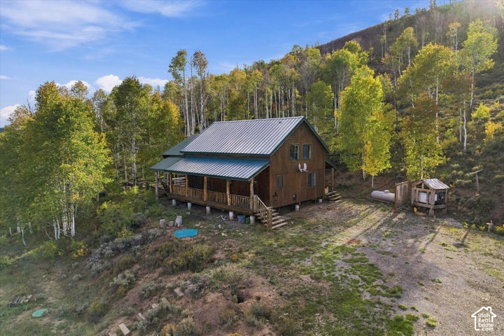 Wood-sided dwelling with a metal roof and a covered porch featuring natural wood posts