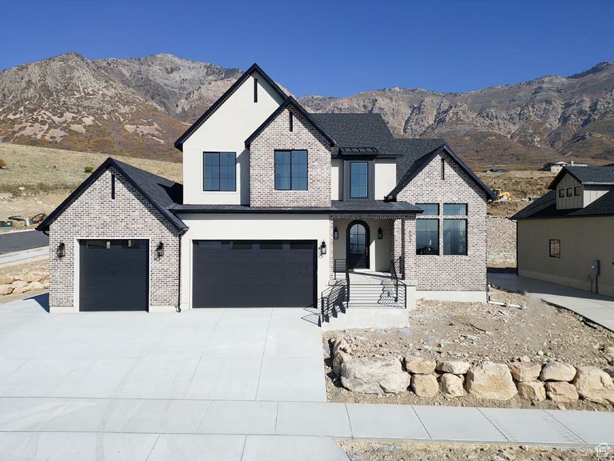 This beautifully designed custom home offers breathtaking views of Ben Lomond Peak, the valley, and the lake through the large windows throughout. The open main level features custom cabinetry, soft-close doors and drawers, quartz countertops, and a gourmet kitchen with stainless steel appliances and a hidden butler's pantry.  Enjoy 9' ceilings on both the upper level and in the basement. The primary suite includes a separate tub and shower, double sinks, and a large walk-in closet with washer and dryer hookups. Custom tile work throughout adds a high-end touch.  Relax on the large covered patio with unobstructed mountain views. No backyard neighbors. Additional highlights include a double-deep 3-car garage, 36' RV pad, and an unfinished basement ready for your personal touch.