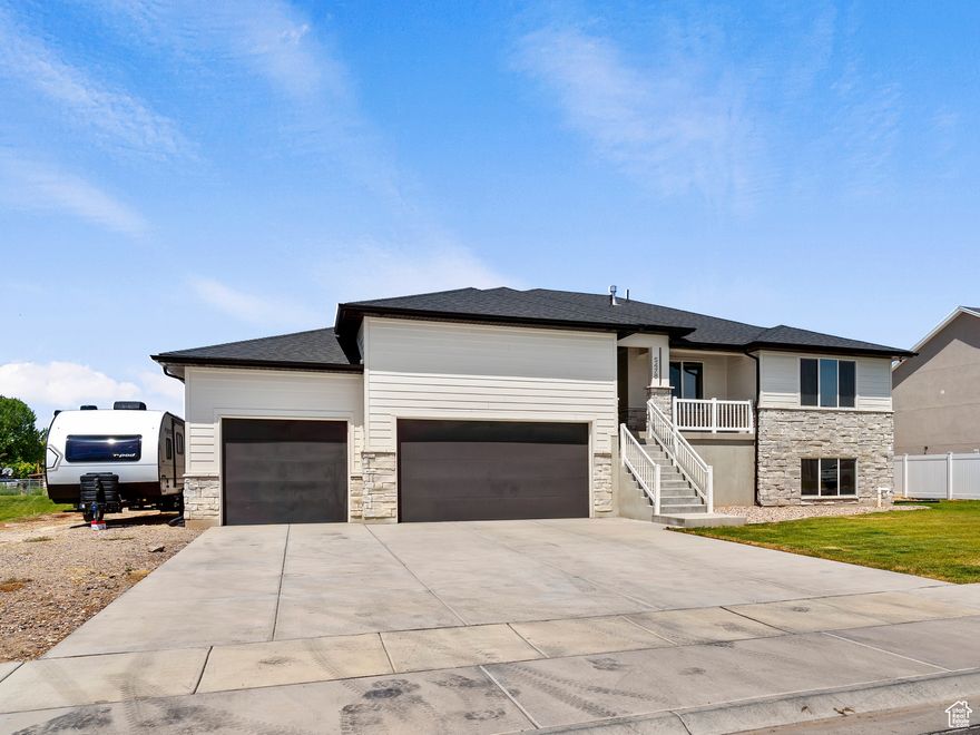 Price just dropped to $799,000! Nearly  acre, a 4-car garage with RV parking, and a finished basement-this Hooper home in the Silver Saddle Subdivision has so much to offer. You'll love the open main living area with vaulted ceilings, natural light, and a dining space that opens to a covered deck for easy indoor-outdoor living. The kitchen offers generous pantry space and great flow for entertaining. The basement is 90% finished with a huge family room, cold storage the size of the front porch, multiple closets, and plumbing ready for a second kitchen-perfect for hosting guests or creating a future income opportunity. All windows include electronic blinds, adding comfort, convenience, and real value. Outside, the oversized 4-car garage with tandem bay and wide driveway gives you plenty of room for toys, trailers, or extra vehicles. No HOA and no neighbors to the west-just space, privacy, and potential to make the backyard your own.