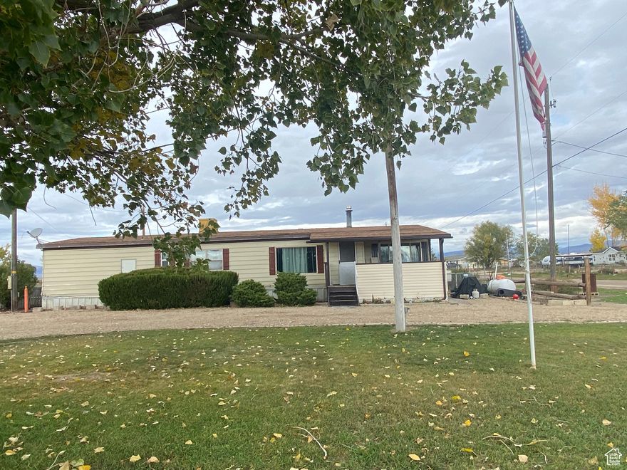 Square footage figures are provided as a courtesy estimate only and were obtained from ~APPRAISAL~.  Buyer is advised to obtain an independent measurement.  Set on open, peaceful acreage surrounded by pastures, this older 3 bedroom 2 bath manufactured home offers country living with plenty of room to grow. Kitchen area is open to the dining area and living room.  Cozy gas free standing stove is located in the living room.  The primary bedroom has a shower and separate garden tub.  Property includes several acres, water shares and wheel  lines. This is perfect for all your livestock needs.