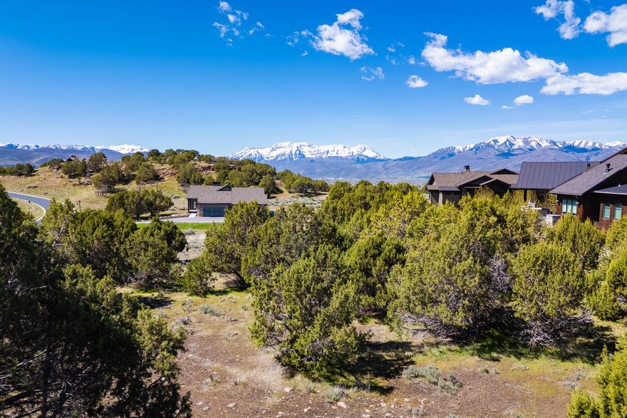 Nestled within the striking natural landscape of Red Ledges, this private homesite offers an exceptional opportunity to create a refined mountain retreat. Spanning over three-quarters of an acre, the gently sloping, downhill build site is surrounded by native juniper trees and showcases sweeping views to the south and southwest, including Mount Timpanogos, all framed by protected open space that enhances both privacy and serenity.  Ideally positioned to capture the beauty of its surroundings, the homesite also provides convenient access to Red Ledges' thoughtfully curated lifestyle amenities including resort-style pools, fitness facilities, tennis and pickleball courts, and casual and fine dining options. Nearby, residents enjoy access to an extensive trail system for hiking, biking, and horseback riding, as well as a well-appointed equestrian center. Seasonal conveniences such as the Deer Valley shuttle further elevate the ease of mountain living.  This property includes the opportunity to secure a Lifestyle Membership, providing access to the community's wide array of amenities and experiences - perfectly suited for those seeking an active, social, and nature-focused lifestyle beyond the golf course.