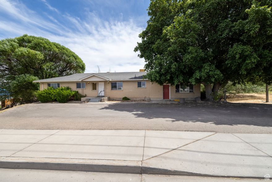 Prime Commercial Location on HWY 40! Take advantage of this high-visibility, high-traffic location next to Velocity Car Wash in Vernal, UT. This versatile office building offers over 4,400 sqft on the main level and basement, with the potential to divide into up to 5 separate suites-perfect for multiple tenants or a growing business. Built in 1976, the property includes a 724 sqft detached garage, shed and sits on a .76-acre lot, providing ample parking and accessibility. Included is a 12.5% interest in a water share (seller has knowledge but does not warrant its function). A rare opportunity to own or invest in one of Vernal's most visible commercial corridors!