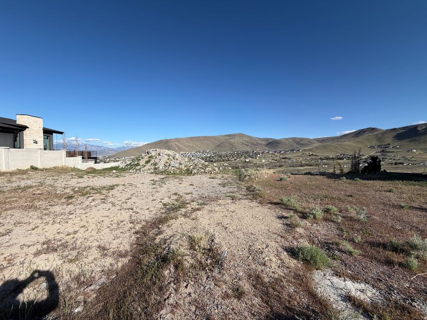 Perched at the end of an elevated cul-de-sac, this exceptional lot in The Ridges at Rose Canyon offers stunning east-facing views and rare privacy. Overlooking a protected green space, it ensures unobstructed vistas of the surrounding canyon and the majestic Wasatch Mountains. The perfect setting to build your dream home, this property provides the freedom to choose your own builder and design a residence that captures the breathtaking panorama.  This desirable location combines tranquility with convenience-tucked away in a quiet neighborhood yet just minutes from Mountain View Corridor, Bangerter Highway, and the vibrant Mountain View Village shopping and dining hub. Outdoor enthusiasts will appreciate the nearby recreation options, from hiking the scenic Yellow Fork Canyon Park trails to enjoying beach and water activities at Black Ridge Reservoir.