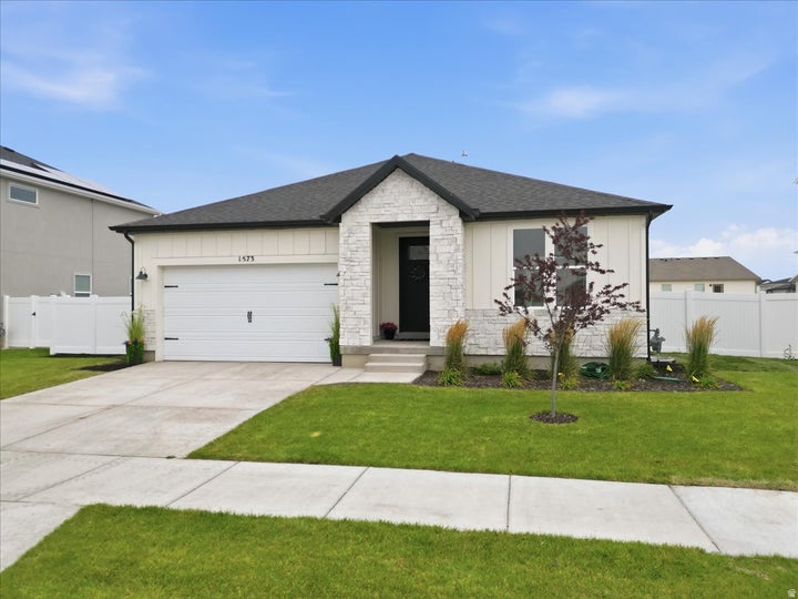 Contemporary single-story residence with white vertical siding and stone veneer accents