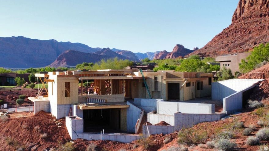 Experience elevated desert living in this remarkable custom home by Shakespeare Development, offering over 7,000 square feet of luxury and design excellence. Perfectly positioned to capture the breathtaking red rock views, this residence seamlessly blends modern architecture with the natural beauty of its Entrada surroundings. Designed for both comfort and entertaining, the home features two expansive levels, two family rooms, a private gym, and an inviting office. The gourmet kitchen and open-concept living spaces flow effortlessly to the incredible outdoor living area, where a resort-style pool and multiple lounging spaces create the ultimate retreat. With 4 spacious bedrooms, 6 luxurious bathrooms, and an oversized 5.5-car garage, every detail has been thoughtfully crafted for an unparalleled lifestyle of sophistication and comfort.
