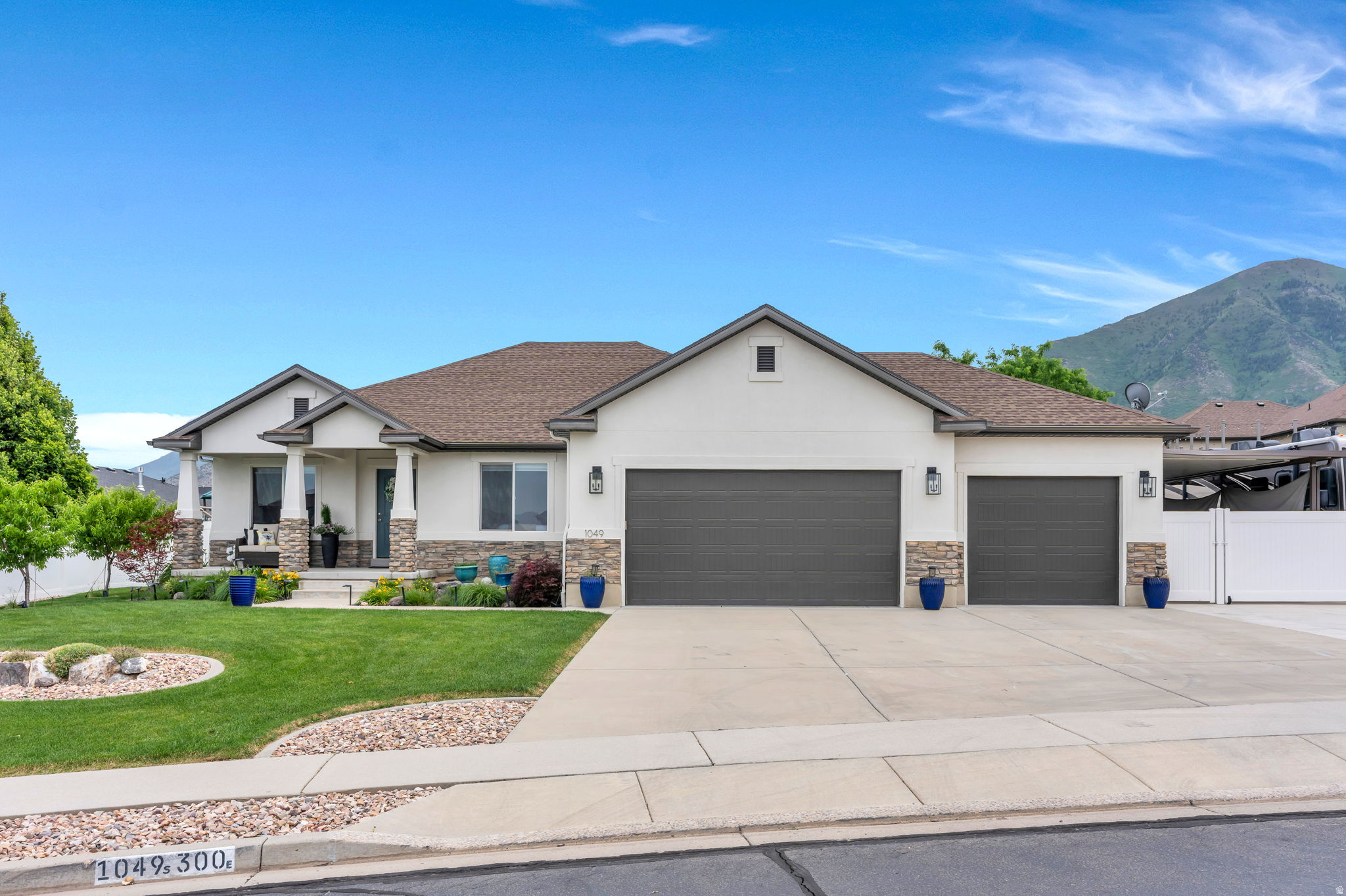 Ranch-style residence featuring a stucco exterior with stone accents and a covered porch