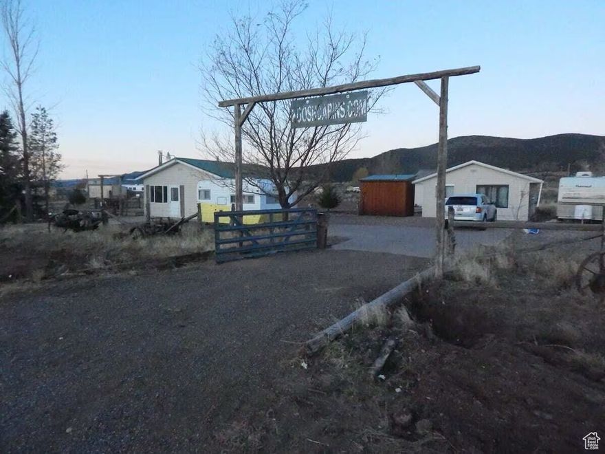 Unique country property featuring 3 separate buildings, lighted pavilion with outdoor grill, vintage travel trailer, and historic wagon with a queen bed inside. All furnishings included. The property has been used as a family getaway and nightly rental for the past several years. Sleeps 18, plus room for camping, trailers, and more! The main building holds a kitchen, small living room with wood burning stove, stackable washer dryer, and a bedroom with a full bathroom attached. The second building has a large living room with TV and sectional sofa, small kitchenette, dart board, bedroom and full bathroom. The third building is a 2 car garage that has a separate entrance to a "bunk room" with custom built in bunk beds that sleep 4, as well as a queen bed. Outside is a stand-alone restroom with a half bath on one side and a separate shower on the other. The vintage trailer sleeps 2 and comes with the property, as does the covered wagon holding a queen bed. The outdoor pavilion has a Blackstone grill with flat-top and grill top connected to house propane, as well as several picnic tables. The property also has several fire pits and a horseshoe pit!