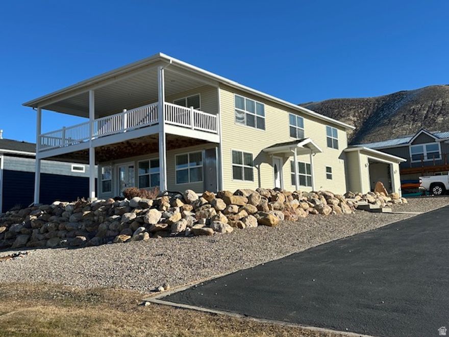 VIEWS!!! This home sits on 2 lots. It is lake front with a grass covered area. No better view than what this home offers. Home is set up for full summer recreation. Huge garage that can fit boats and ATV's Garage sits on one lot and the home on the other lot (home and garage is connected).  East shore. This home is in an area that no nightly rentals are allowed. So extra quiet. Walk right out and enjoy the beach and lake. A must see.