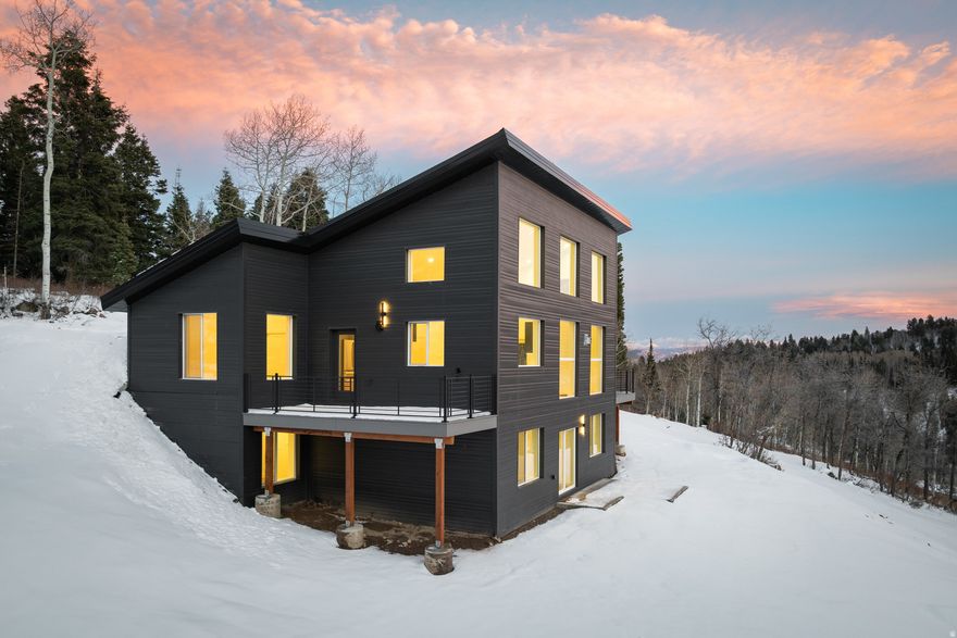 This mountain-modern home was built for longevity, efficiency, and ease of ownership. Constructed with ICF concrete walls, steel siding, and a metal roof, it prioritizes durability and low maintenance in all seasons. Inside, the home features engineered hardwood floors, a whole-house water filtration system, and radiant in-floor heat throughout, powered by a high-efficiency hydronic boiler. Eight heating zones with smart thermostats (four per level) provide precise comfort and strong energy performance.  The layout includes 4 bedrooms and 3 bathrooms, including the option of two primary bedrooms - one for main level living, the second lower-level en-suite featuring French doors. At 2,556 square feet, the home offers two full living areas, a wet bar hookup on the lower level, dual washer/dryer hookups on both floors, and a southeast-facing orientation with large windows that fill the home with natural light. The lower level is a true walkout, ideal for guests, multi-generational living, or a dedicated workspace.  The home comes prewired for Starlink and media systems, making it fully plug-and-play for remote work or streaming. Additional features include Energy Star appliances, dual-flush toilets, an induction stove, an open patio space, and a gas BBQ stub. Positioned on a plow route with year-round access, this home offers an effortless lock-and-leave lifestyle.  Built with purpose, the property combines high-end systems, thoughtful engineering, and long-lasting materials in a modern mountain setting just 25 minutes from Main Street Park City and 45 minutes to Salt Lake City International Airport. Perfect for buyers who value construction quality as much as design. Welcome to this newly constructed, move-in-ready home in the charming mountain community of Tollgate Canyon.