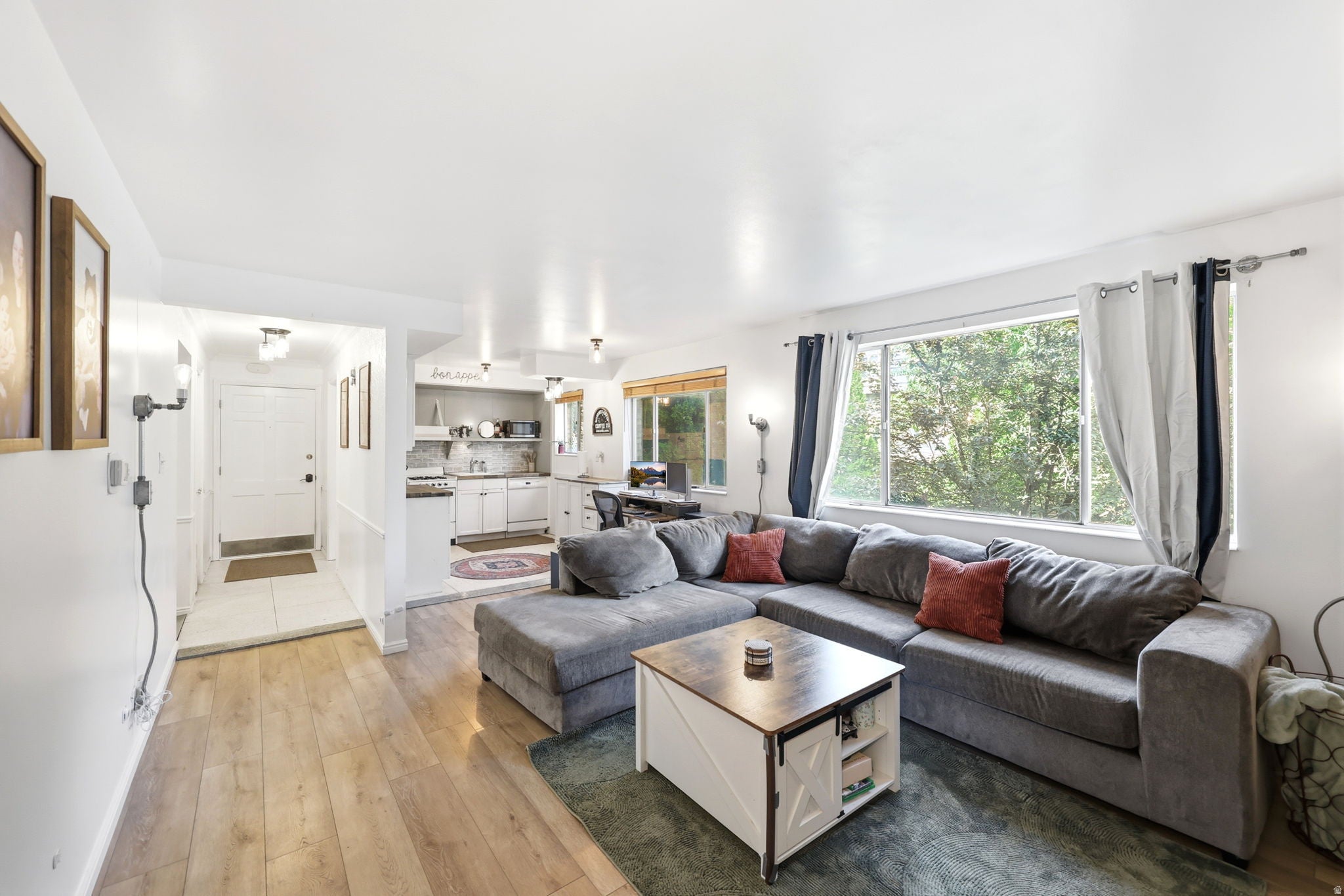 Living area featuring wood-finish flooring, a large picture window, and recessed lighting