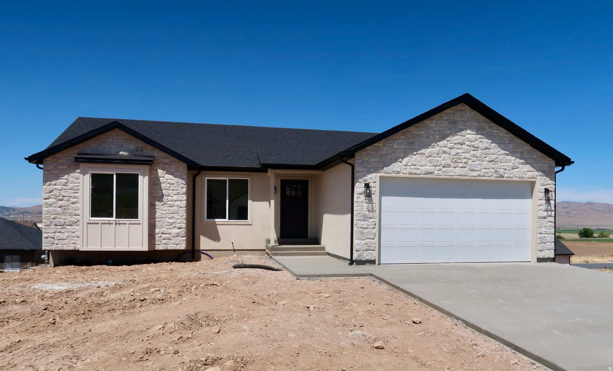 Exterior facade featuring a combination of light-colored stacked stone and smooth stucco