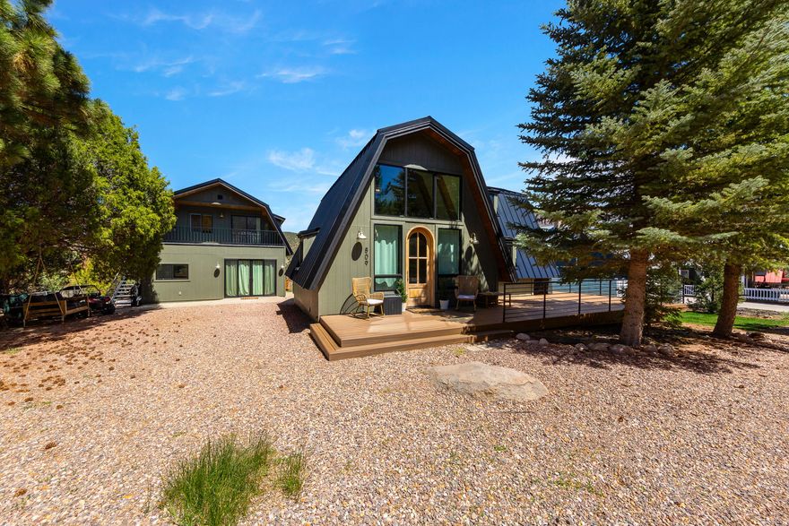 Imagine stepping into your own fully furnished mountain retreat, where everything has already been beautifully redone and is ready for you to enjoy from day one. This rare dual-cabin property sits on a spacious 1/3-acre lot and offers the perfect blend of comfort, charm, and flexibility.  The main cabin welcomes you with warmth and character, featuring 3 bedrooms and 1 bathroom, ideal for cozy nights, gathering with loved ones, and creating lasting memories.  Tucked behind, the second cabin adds incredible value and versatility. With a private bedroom and additional bunk space, it's perfect for hosting guests, accommodating larger groups, or generating rental income.  Step outside and experience what truly sets this property apart. The expansive yard is designed for fun and relaxation, complete with an in-ground trampoline, playset, hot tub, and multiple spaces to unwind, including a deck, patio, and fire pit under the stars.  Whether you're searching for a turnkey vacation home, a place to gather with friends and family, or an income-producing retreat, this Pine Valley property offers a lifestyle you won't want to miss.  Come see it for yourself and fall in love.  Square footage figures are provided as a courtesy estimate only and were obtained from county records.  Buyer is advised to obtain an independent measurement. Total square footage (2,228 sq ft) includes both cabins on the property, front cabin (1,306 sq ft) and rear cabin (922 sq ft). Each offers a full kitchen, with utilities shared between the two.