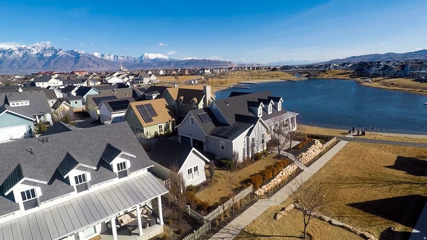 Steps from Oquirrh Lake in Daybreak's Lake Village, this classic 4,000+ sq. ft. Rainey home is the ultimate launchpad for a life well-lived. An open-concept layout anchored by a grand kitchen makes hosting effortless, while 5 spacious bedrooms and 4 bathrooms provide ample room for everyone. Elegant finishes flow through the main floor, which features a private primary suite, an oversized laundry room, and a fully equipped wet bar designed for high-end entertaining. Whether you're enjoying a sunrise paddle or a vibrant lakeside sunset, this home offers a rare opportunity to embrace a lifestyle where every day feels like a weekend. Square footage figures are provided as a courtesy estimate only and were obtained from county records. Information is deemed reliable but not guaranteed. Buyer and buyer's agent to verify all.