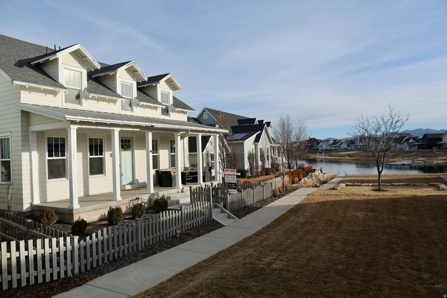 Steps from Oquirrh Lake on Daybreak's Lake Village, this classic 4,000+ sq. ft. Rainey home is the ultimate launchpad for a life well-lived. An open-concept layout anchored by a grand kitchen makes hosting effortless, while 5 spacious bedrooms and 4 bathrooms provide ample room for everyone. Elegant finishes flow through the main floor, which features a private primary suite, an oversized laundry room, and a fully equipped wet bar designed for high-end entertaining. Whether you're enjoying a sunrise paddle or a vibrant lakeside sunset, this home offers a rare opportunity to embrace a lifestyle where every day feels like a weekend. Square footage figures are provided as a courtesy estimate only and were obtained from county records. Information is deemed reliable but not guaranteed. Buyer and buyer's agent to verify all.