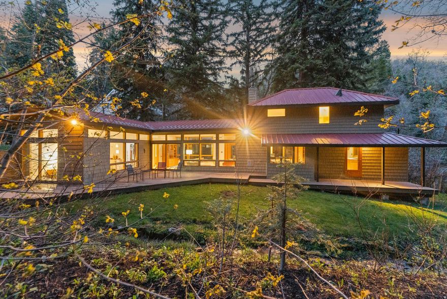 Scenic creekside contemporary two-story in Pinecrest Canyon. Thoughtfully designed and expanded by a prominent local architect in 1989. Surrounded by natural beauty, the property features towering pine trees, flat usable acreage, a year-round flowing stream, red rock views, and easy vehicular and pedestrian access. Welcoming, attractive wood-shake siding, redwood entry and rear yard deck, and red metal, standing-seam roofing. An oversized two-car garage includes a dedicated gear/workroom, perfect for storage or hobbies. Inside, the main floor offers an open and airy feel with a high and vaulted ceiling, abundant wood-grain casement windows, and solid-core doors throughout. The flooring is a tasteful blend of hardwood, stone, and natural wool carpet. Both bathrooms have been updated with quartz countertops and handsome twenty-inch tile finishes. The primary suite and family room are on the main floor with easy access to the rear yard and back deck. A centrally located gas fireplace can be enjoyed from either the living room or family room. And then - it's all about Pinecrest Canyon. Rising above the Gambel oak and high desert chaparral of the surrounding Emigration area, Pinecrest is widely regarded as the Canyon's most unique, scenic setting. Here, red rock formations and towering pines create a dramatic landscape, complemented by the rare presence of a reliably flowing year-round stream on the property. Enjoy sweeping southern views of Mount Raymond and Gobbler's Knob, and hiking, biking, or snowshoeing and backcountry skiing right out your doorstep. *Portions of the video are AI enhanced.*