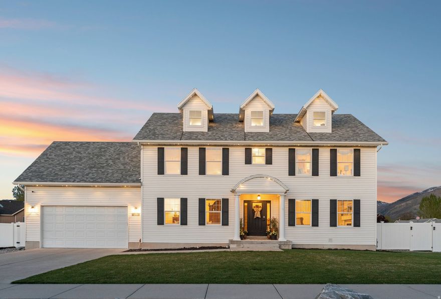 If you've been searching for a home that truly stands out, this is it.  Located in a quiet, well-established neighborhood of Nibley, this charming colonial-style home offers a rare blend of timeless design, functional living space, and thoughtful updates throughout. With over 3,300 square feet, every inch of this home has been intentionally designed to feel both spacious and inviting.  The main level features a warm and welcoming layout with multiple gathering spaces, a formal dining area, and an open kitchen complete with granite countertops, stainless steel appliances, and a large island-perfect for hosting or everyday living. Natural light pours in through oversized windows, creating a bright and comfortable atmosphere throughout the home.  Upstairs, the expansive primary suite provides a private retreat with dual walk-in closets and a well-appointed bathroom featuring double vanities, a soaking tub, and separate shower. Additional bedrooms offer flexibility for family, guests, or workspace needs.  One of the most unique features of the home is the bonus loft tucked away above, offering a versatile space ideal for a playroom, office, or additional lounge-something you won't find in most homes.  Step outside and take in the views. The large elevated deck captures stunning mountain scenery, while the fully fenced backyard includes a covered patio and plenty of room to relax, entertain, or enjoy the outdoors. Positioned on a corner lot with full landscaping, this property offers both privacy and curb appeal. Buyer and Buyer's agent to verify all information.