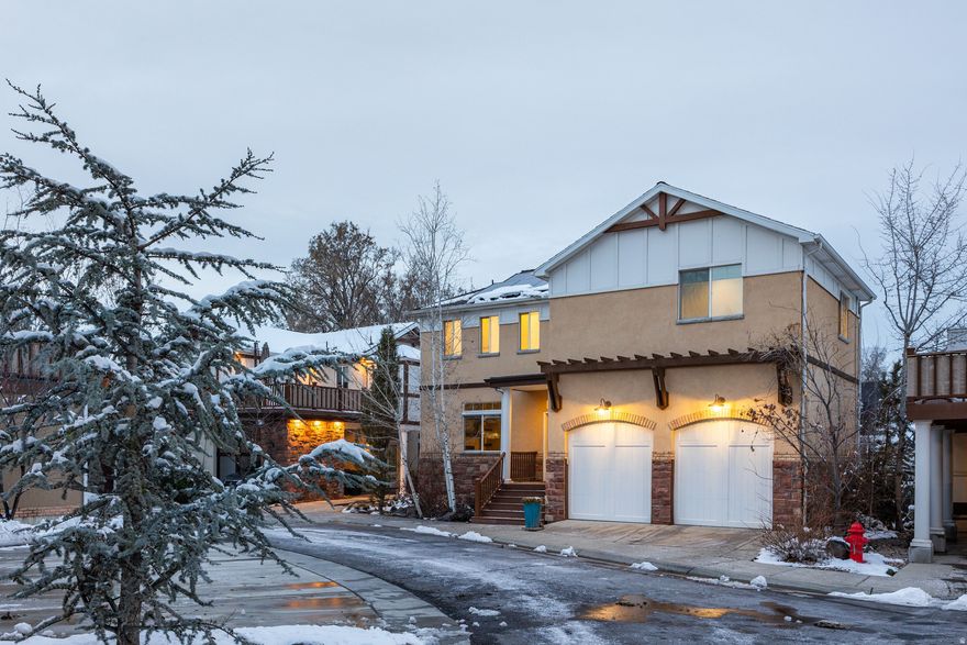 Welcome home to 1195 South Liberty Wells Place! This sophisticated two-story residence offers a thoughtfully curated floor plan with elevated design throughout. An open entry with oversized barn doors leads to a dedicated office or formal living featuring a tiled gas fireplace, wood mantle, floating shelves, and a striking picture window. The kitchen and great room create an ideal entertaining space with white cabinetry, high-end stainless appliances, classic subway tile with herringbone detail, and a statement island with pendant lighting and bar seating. A walk-in pantry with prep space and custom lighting adds both function and style.  Upstairs includes three spacious bedrooms, two baths, laundry, and a private deck with mountain views. The primary suite is a true retreat with dual walk-in closets, double vanities, an oversized soaking tub, and direct access to the deck.  The basement boasts exceptional ceiling height, a wet bar with wine fridge, a dramatic floor-to-ceiling herringbone fireplace, theater lighting, and a private guest bedroom with a three-quarter bath. Substantial storage, a mudroom, and built-in cabinetry enhance everyday livability.  Custom finishes include quartz countertops, upscale flooring, LED lighting, wired ethernet, dual HVAC, solar panels, and an extra-deep two-car garage wired for EV charging.  Located in Liberty Wells within an intimate planned cul-de-sac community of thirteen custom homes, just moments from Liberty Park, local dining, and Sugar House amenities. Finally a home that reflects your style!