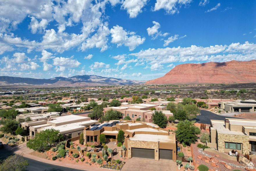 Welcome to this stunning 2011 Parade Home in the Cliffs at Snow Canyon. The entry sets the tone with a custom metal courtyard gate, stone water feature, paver courtyard, and striking glass, wood, and iron front door. Inside, the living room features large windows with red rock views, a Venetian plaster fireplace, backlit recessed ceiling detail and built-in entertainment center with Hunter Douglas electric blinds. The Chef's Kitchen is a highlight with Thermador appliances, granite countertops, a copper range hood and copper sink, island bar, custom backsplash, and built-in refrigerator, oven and dishwasher. The dining area sits beside large windows that bring in natural light and views. The primary suite offers patio access, a Venetian plaster fireplace, and a spa bathroom with double vanities, jetted tub, walk-in shower, vanity table, Kohler fixtures, and a custom walk-in closet with skylight, drawers, and shelves. Two guest bedrooms each include their own en-suite bath and walk-in shower. An office with built-in bookcases and a desk with drawers add function and versatility. Throughout the home, you'll find travertine floors, wood baseboards, solid wood doors, shutters, and wood window frames, as well as convenient bedside lighting controls in each bedroom. A skylight brightens the garage entry, while the oversized 3-car garage includes epoxy floors, storage cabinets, a sink, and countertop. Outdoor living shines with a large covered paver patio with fire pit, built-in outdoor kitchen with BBQ grill, gas cooktop, sink, and storage. The exterior features recently painted stucco and stone accented with lichens, and blends beautifully with the desert setting. The home also features a security system, solar panels, and Samsung battery walls. Owners enjoy access to the community pool, tennis courts, and clubhouse, with the option to join Entrada Country Club Social Membership. Furniture package available.. The home is a short drive to the sheer massive cliff walls of Zion National Park, the hoodoos of Bryce Canyon National park, or the North Rim of The Grand Canyon. There is no place like it. You can drive to Tuacahn, Snow Canyon State Park, and Fire Lake within 5 minutes. Enjoy nearby hiking, biking, and outdoor adventures or any of the 4 amazing large reservoirs and thousands of recreational public acres for the adventurous at heart. Scout cave can be found on the cliffs just above the home. The region is also known for its internationally renowned golf courses that recently hosted the PGA tournament and will soon host the LPGA. Saint George is also the host for many events such as the Ironman, Red Bull Rampage, and the Saint George Marathon. All information herein is deemed reliable but is not guaranteed. The buyer is responsible to verify all listing information, including square feet/acreage, to the buyer's own satisfaction.