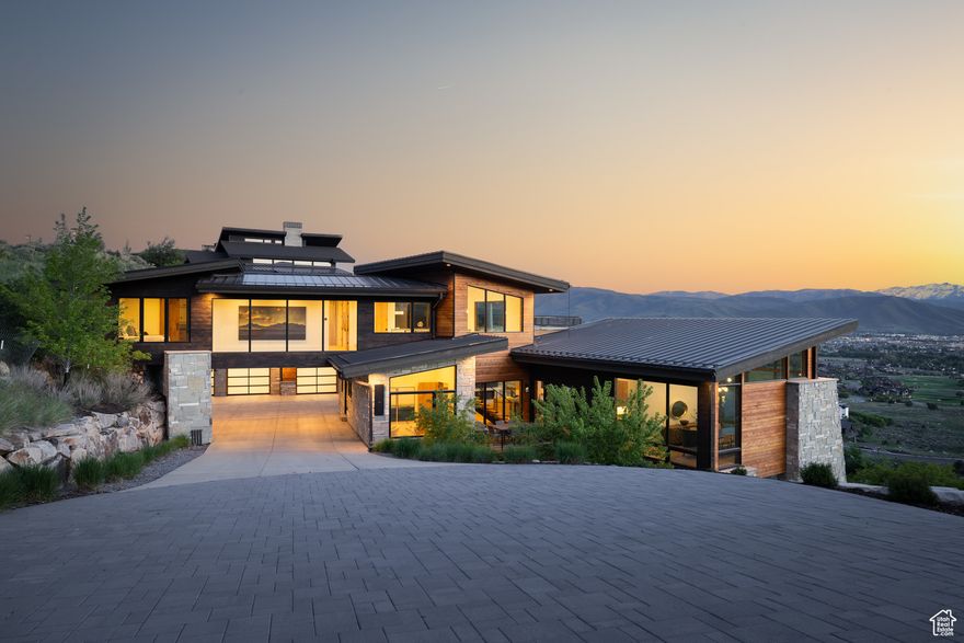 This remarkable mountain contemporary home stands out as one of Red Ledges' most striking and thoughtfully crafted residences. Built by luxury home builder Pure Haven Homes, it is located on a premier ridgeline, offering sweeping, uninterrupted views of the Heber Valley and the iconic silhouette of Mt. Timpanogos.  From the moment you enter, you're greeted by stunning architecture, soaring ceilings, and walls of glass that capture the grandeur of the surrounding landscape. The open-concept layout is both elegant and functional, anchored by a chef's kitchen that features a full butler's pantry and a separate prep kitchen - ideal for seamless entertaining and everyday convenience.  The primary suite is a true sanctuary, cantilevered to maximize views and wrapped in floor-to-ceiling windows. The spa-inspired bathroom is complemented by dual custom closets and a built-in laundry station - combining comfort with refined luxury. The lower level is designed for gathering and recreation, with a generous family room, game and media zones, and a custom bunk room perfectly suited for visiting family and friends.  A Red Ledges Golf Membership is available with deposit, offering access to the community's award-winning lifestyle. Spanning nearly 2,000 acres, Red Ledges offers world-class amenities including the Jack Nicklaus Signature Golf Course, Jim McLean Golf School, Cliff Drysdale Tennis School, a resort-style pool and fitness club, and private equestrian facilities.  Just 20 minutes from Park City and minutes from Deer Valley skiing, Red Ledges members also enjoy exclusive winter access to three private ski lounges at Deer Valley, accessed by our private shuttle services. This is a rare opportunity to own a home that combines architectural excellence, dramatic views, and one of the most complete amenity packages in the Wasatch Back.