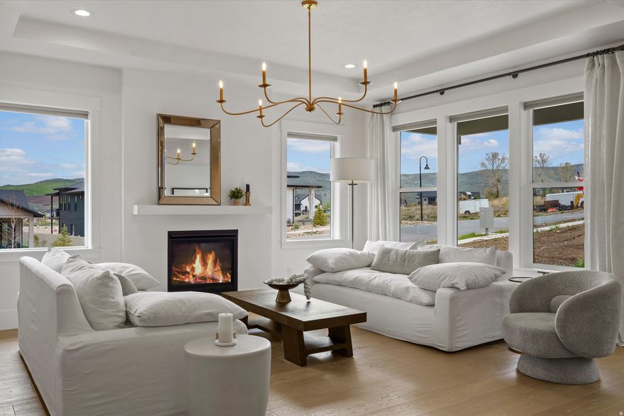 Located in The Cottonwoods, one of Mountain Green's most sought-after communities, this nearly new residence offers a refined balance of elevated design and low-maintenance living. With just one year of light use, the home presents in exceptional, like-new condition. Positioned on a desirable corner lot, it is filled with natural light and finished in a cohesive, designer-curated palette that carries seamlessly throughout. The main level is anchored by Mohawk engineered hardwood flooring and a thoughtfully designed kitchen with a large island, quartz countertops, GE Caf appliances, and elevated designer lighting-equally suited for everyday living and effortless entertaining. The fully finished basement extends the home's livability with a spacious great room, 100% wool Karastan carpeting, and three additional bedrooms, including a private en suite. Just outside your front door, enjoy access to miles of community trails and nearby parks, with world-class skiing at Snowbasin Resort only a short drive away.  This spring the developer will be finishing the professionally maintained landscaping which enhances the home's clean, lock-and-leave lifestyle-offering a rare combination of comfort, quality, and understated luxury in one of the area's most desirable settings.