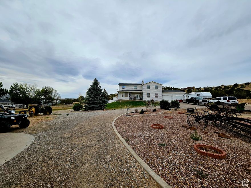 Located on North Vernal Bench along North 2500 West, this two-story, 5,217 sq ft home with a finished walk-out basement offers six bedrooms and 3.5 bathrooms. The main level features a family room with wood-burning stove and a kitchen with double oven. The primary suite includes a soaker tub. Four bedrooms are upstairs, one on the main level, and one in the basement. The home sits on 2.20 acres (three parcels: 1.10 acres with the home, shop, outbuildings; 1.12 acres with 1 acre foot irrigation water, 10 ELUs stock water - Well Water Right 45-5944). Garage parking enough for 10 vehicles: 30x55 (1650 sqft.) 4-bay shop (10' height by 12' doors), Oversize 2-car (26x27) attached garage), plus RV and outdoor parking for 25+ vehicles. Features include mature pine and fruit tree's, a fully fenced backyard, automatic sprinklers, and an aluminum walk-out deck form the main level. Connected to central air and heat, city culinary water, city sewer, Rocky Mountain Power electric, and Embridge gas, gas dryer hookup. No HOA; zoned for horses. Located in the Uintah School District (Maeser Elementary, Vernal Middle, Uintah High). Contact listing agent for details or to schedule a showing. Pool table in basement is included.