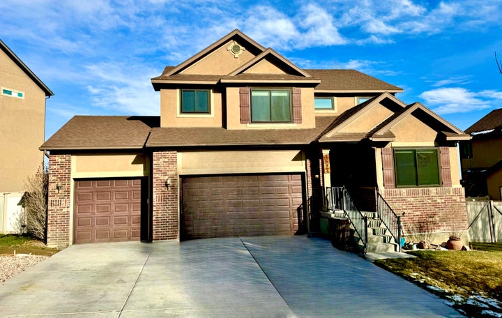 Craftsman-style house with brick siding, concrete driveway, and stucco siding