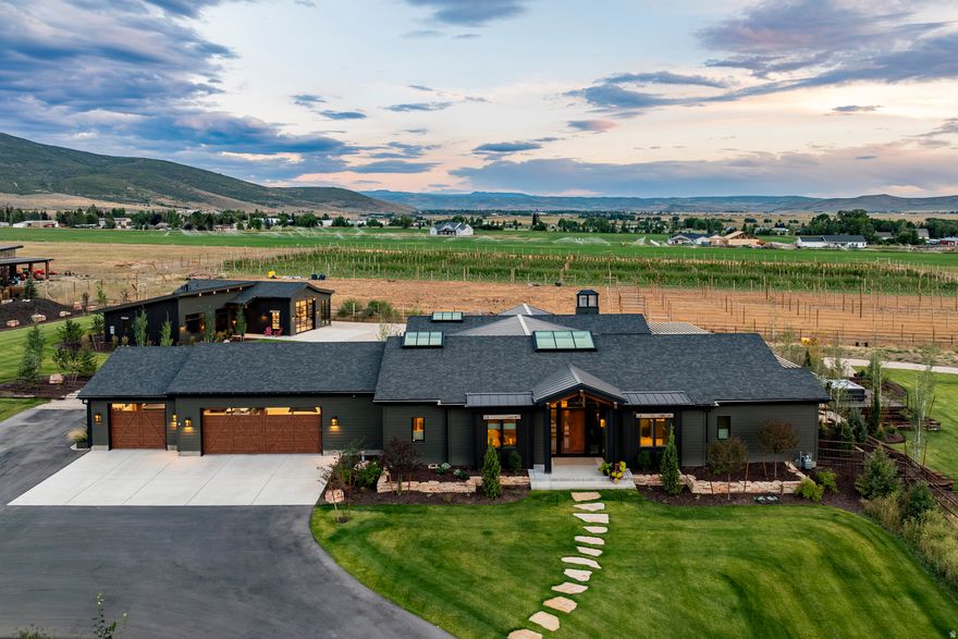 Welcome to Utah's Best: A boutique Farm exuding rural/cosmopolitan perfection! Less than 20 mins to Deer Valley East Village, 25 mins to downtown Park City. We are thrilled to present a rare and unique opportunity to own a perfectly sized slice of Utah farmland heaven in the sought after, and highly coveted Marion/Kamas Valley. Set within the gated Lazy Acres community, this newly built, single-level modern farmhouse offers over 4,000 square feet of artisan-crafted living space on 7.2 contiguous acres-one residential lot and two agricultural parcels-fully fenced with generous water rights and a pressurized irrigation system. Impeccably engineered, meticulously constructed, and artfully designed, this home blends luxurious comfort with unmatched functionality. Inside, a playful yet refined mix of wood, steel, and glass complements high-end finishes and radiant in-floor heating throughout. The chef's kitchen showcases professional grade appliances- proudly made in the USA and born from the commercial world, now defining the ultra-luxury residential market. A fully finished 5'+ high "crawl space" runs the entire length/width of the footprint, providing a secondary workspace, ample storage, or a built in "safe room/storm shelter". The main residence includes two spacious, luxurious and airy En-Suite bedrooms, while the impressive "Garage-Mahal/ADU" adds an additional ensuite bedroom, full kitchen, living area, and a versatile man-cave/workspace/lounge. Outdoor living shines with a custom timber-frame pergola, heated 3-car garage, natural gasplumbed grill patio, a perfectly positioned sunken hot tub patio, with STUNNING westerly views across thousands of acres of additional Open Space and snowmelt-equipped metal roofs. Two natural-gas backup generators (one for each stand-alone structure) ensure un-interrupted seamlessly connected living, and along with extensive smart-home systems provide whole-property control. Fully landscaped, individually fenced and ready for horses or pets, 307 West Lazy Acres Lane delivers the rare blend of cutting-edge infrastructure, seclusion and privacy, VIEWS, and timeless mountain style. Call for Private Showings. ** Furnishings and farm equipment are negotiable**