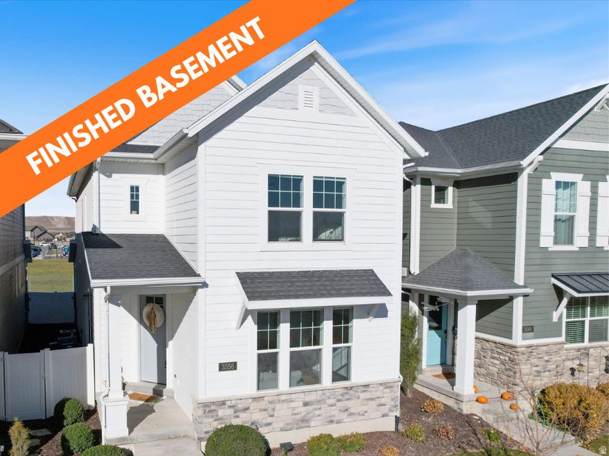 Welcome to your one-of-a-kind home in the highly sought-after Holbrook Farms community! Unlike standard builder-grade homes, this property stands out with custom craftsmanship and designer upgrades throughout. The professionally finished basement (completed Dec 2022) adds 700 sq. ft. of versatile living space-perfect for entertaining or easily converting into a studio apartment with its full bath, sink, and microwave. Enjoy custom-built entertainment centers on both levels with designer hardware and finishes. Every detail has been elevated-from upgraded lighting throughout the home to custom window trim, shiplap accent wall, and stunning woodwork in the primary suite. Even the laundry room has been raised for convenience and style. Situated on a premier lot with no front or back neighbors, this home enjoys open green space from the new elementary school directly behind, filling the home with natural light and privacy. Plus, there are thoughtful touches throughout designed with young kids in mind-you'll have to see them to appreciate the charm and convenience they bring. The location is unbeatable-just 2 minutes to Intermountain Primary Children's Hospital, 5 minutes to I-15 and Thanksgiving Point, 15 minutes to Camp Williams Military Base, 22 minutes to Utah Lake Boat Harbor, and 42 minutes to Sundance Ski Resort. Luxury, comfort, and location - this home truly has it all!  NEGOTIABLE ITEMS: Tonal 1st Generation Gym, appliances, furniture, Tesla battery charger