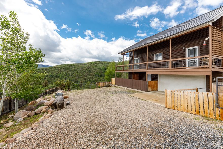 Nestled in the landscapes of Huntsville Evergreen Park, this stunning cabin-style home offers a unique blend of convenience and rustic charm. Featuring three inviting primary suites, each thoughtfully designed this property is perfect for hosting  or simply enjoying a peaceful escape from the hustle and bustle of daily life.  2.5 glorious acres with additional land available. Step out onto the expansive deck, where views of majestic red rock formations and surrounding mountains will captivate your senses. As you enter the home, the warm ambiance draws you in, thanks to a gas fireplace - perfect for cozying up during chilly mountain evenings. This space serves as the heart of the home. Your outdoor adventure starts here! Unwind in your private hot tub under the starlit sky, providing a perfect end to your days filled with excitement. Just minutes away, the pristine Causey Reservoir awaits, offering fishing, boating, and hiking opportunities amid breathtaking surroundings. But that's not all! This property features a substantial barn(48 x 26) equipped with dual garage doors and 220 electric, ideal for storing your beloved toys, horses and/or outdoor equipment. An additional 48 x 10 porch off the barn provides extra space for entertaining or storing essentials. Plus, the versatile 24 x 12 workspace, complete with electric, is perfect for your DIY projects and hobbies! With essential utilities like electric, propane, and septic, along with efficient heating & air conditioning, this home guarantees comfort throughout the year. Located just 15 minutes from the charming town of Huntsville.  Enjoy swimming/boating at Causey and Pineview Reservoirs, or hit the slopes at Snowbasin and Powder Mountain Ski Resorts, both just a short drive away. Don't forget just minutes away  North Fork Park / Dark Sky Park Stargazing / Snow Shoeing   Ogden Historic 25th Street  Club Rec Snowmobile Center / Monte Cristo Snowmobile Park (10 miles)