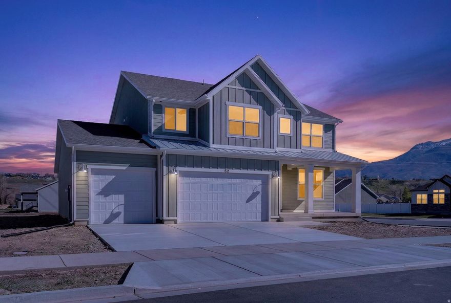 This thoughtfully designed farmhouse-style Rainier floor plan sits on a spacious .34-acre corner lot and offers 4 bedrooms and 2.5 bathrooms with beautiful modern finishes throughout. The bright, open main living area features a cozy fireplace in the great room, creating a welcoming space to relax or gather. The kitchen combines style and function with quartz countertops, elegant two-toned cabinetry, and gold hardware, along with plenty of prep space and a layout that flows easily into the main living area. Multiple living spaces provide flexibility for a home office, playroom, or additional lounge area. Additional highlights include a convenient mudroom/drop zone, an oversized 3-car garage, and an unfinished basement offering room to expand. Ideally located with easy access to Riverdale Road, Hill Air Force Base, Interstate 84, and Highway 89. Say 'Hello!' to your new home and enjoy summer nights here!