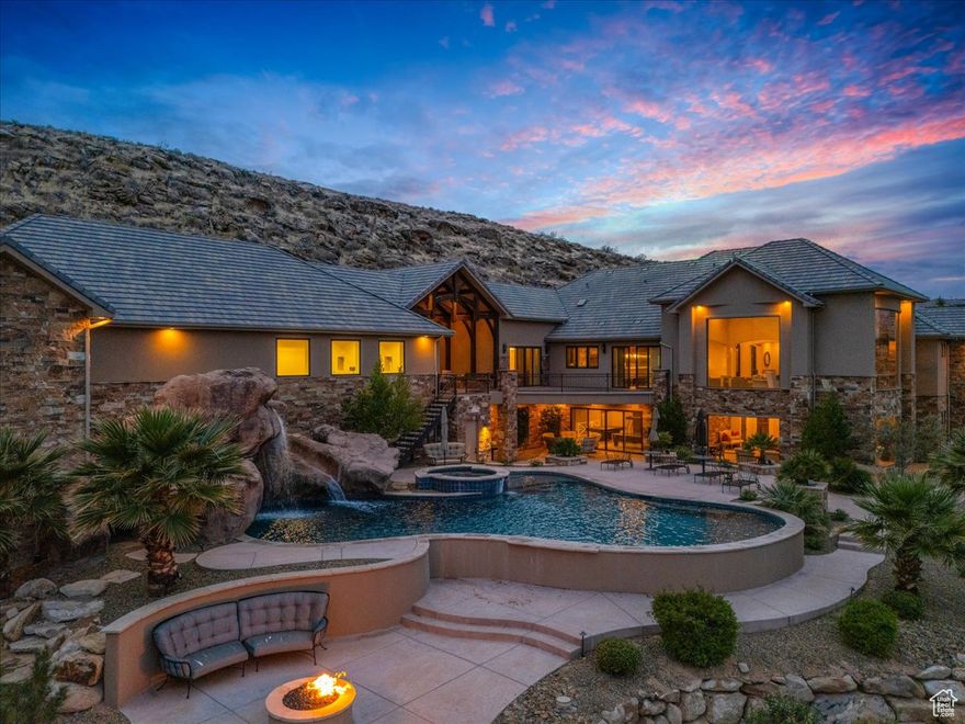 Perched at the top of a gated mountain community, this extraordinary estate boasts breathtaking views of Pine Valley and Zion! The home is a masterpiece of luxury and design, featuring three full kitchens with exotic granite, the main kitchen boasts Wolf appliances, double ovens, oversized Sub-Zero refrigerator, pebble ice machine, two dishwashers, and a huge walk-in pantry. Grand, coffered ceilings, solid wood beams, travertine floors, solid core doors, and shutters create an upscale yet inviting ambiance throughout. The primary suite offers private deck access and a spa-like marble-tiled bathroom. A recently serviced and certified elevator adds convenience and ease of access to all levels. Entertainment and comfort continue with a glowing kid's slide from upstairs to down, a massive family room, a bunk room with 8 beds, a life-sized dollhouse, an exercise room, a 2,000+ SqFt flex space perfect for a gym or golf simulator, and an indoor basketball court with a rock wall and plenty of room for volleyball or pickleball. A private attached casita with its own full kitchen and living room space is perfect for guests or generational living. Outdoor amenities are equally impressive with an expansive covered deck off the main level with a full Wolf outdoor kitchen and fireplace, and on the lower level a fire pit, and a resort-style chlorine pool with a waterfall, rockslide, diving rocks, and hot tub. Smart home features include a Crestron system for the pool, cameras, shades, music, and more! Parking and storage are exceptional with a Tesla charger, RV parking around the back of the home, and an oversized 5-car garage with epoxy flooring, this one truly has it all! Buyer to verify all information, deemed reliable, however buyer to verify all info including utilities, rental restrictions, and HOA information if applicable.