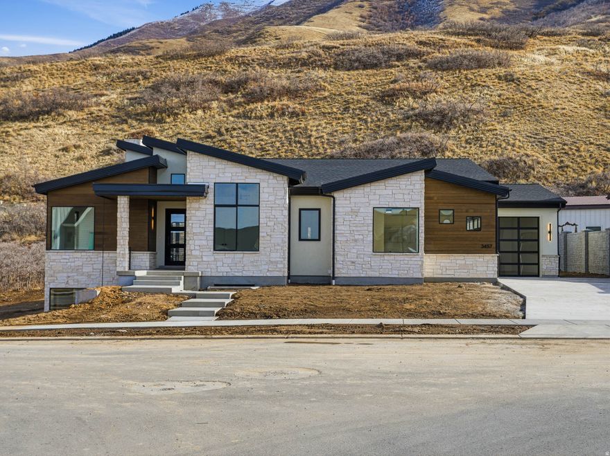 This brand new - just completed modern contemporary house offers impressive mountain views, incredible floor plan with large windows, bright open floorplan and located in a spectacular neighborhood in beautiful south east Mapleton. Loaded with several extras- To name a few.. Hardwood floors throughout main living areas, quartz countertops with full backsplash in kitchen, Sonos system, roughed-in for Generac generator,  sink and storage cabinets in garage, 10' tall basement with walkout, Trim Lights, large spacious deck and covered patios. Enjoy hiking, biking, or riding your offroad toys  with access right from your backyard. This home is ready for an immediate occupancy. Call Troy Shaw Broker/Builder with any questions. We can finish quickly any basement build out to clients liking/budget. Buyer to verify all info.