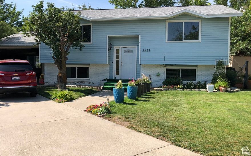 The home includes 5 bedrooms and 2 bathrooms, providing ample room for a large household or rental opportunities. The interior includes updated features such as a remodeled kitchen, modern appliances, and durable flooring throughout the living areas. Heating is provided by a forced-air gas system, along with central air conditioning for year-round comfort. A finished walk-out basement with individual entrance, and above-ground windows adds additional living space and natural light, and the basement layout may allow flexible use such as guest quarters or rental potential. Offering a generous backyard perfect for outdoor activities, gardening, or entertaining. Additional features include covered carport parking for two vehicles, mature landscaping, and space for storage or future improvements. Conveniently located near schools, parks, shopping, and major roads such as Bangerter Highway, the home provides easy access to nearby amenities while maintaining a peaceful neighborhood. Square footage figures are provided as a courtesy estimate only. Buyer is advised to obtain an independent measurement.