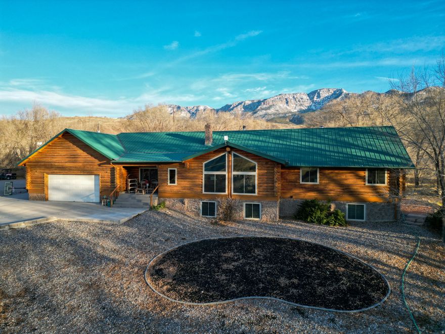 Exquisite home on three acres with captivating views. Sprawling property with abundant space. A fully-equipped dome greenhouse (Growing Spaces brand) with new seam tape is included. The log exterior was recently professionally sanded and refinished (2025). A large rear patio and pergola extend the living space outdoors. Inside, enjoy a vaulted living area, chef's kitchen with granite countertops, and modern appliances. Two water sources, including culinary and an underground well. This home is roomy, with large, flexible rooms and remodeled bathrooms. A raised, daylight basement boasts a separate entrance and kitchenette. Take advantage of this home's layout for multi-generational living or rental income. Three wood-burning stoves add warmth and charm. Wonderful property perched in the foothills.