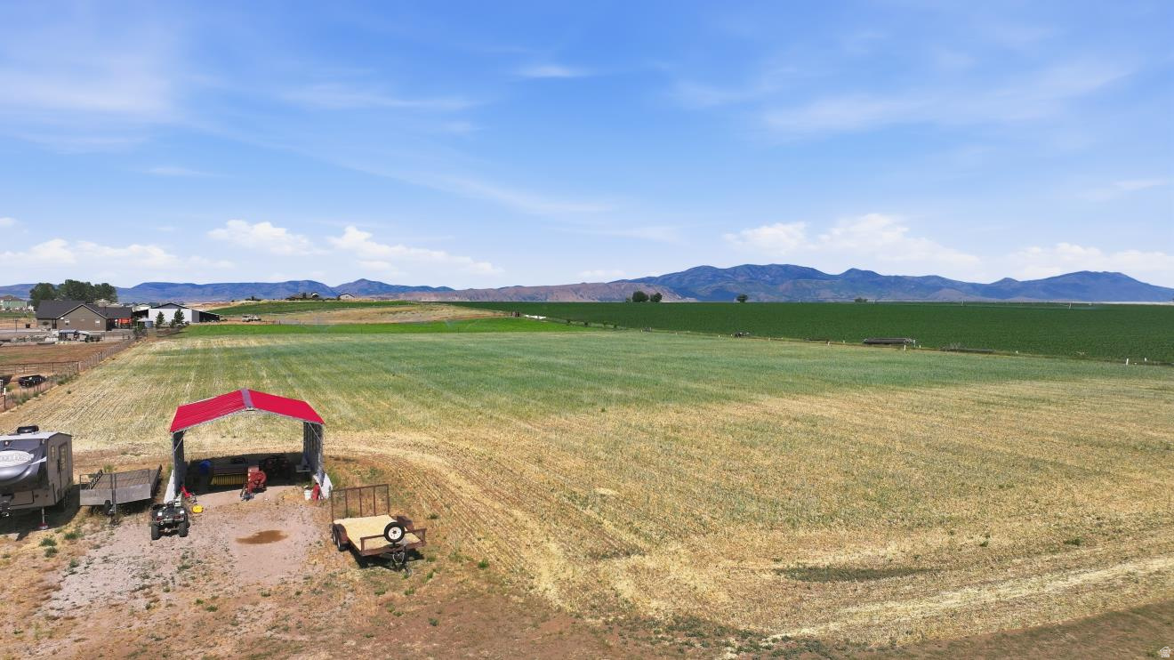 Expansive agricultural landscape featuring large cultivated fields and distant mountain ranges