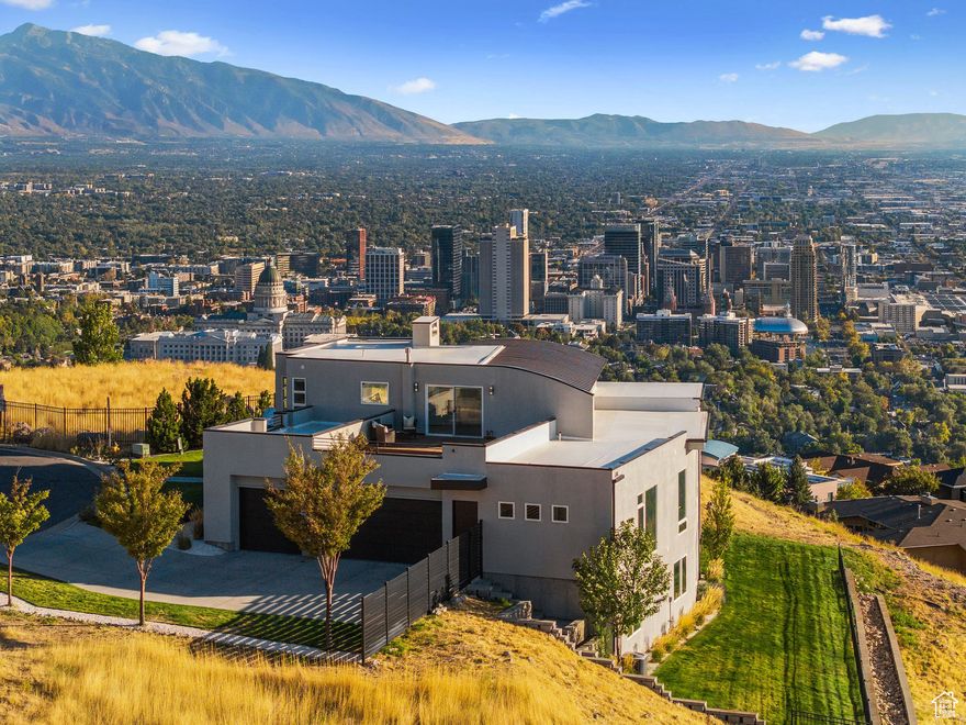 One of the most spectacular properties in all of Salt Lake County. Nestled on a coveted cul-de-sac atop Capitol Hill, this modern 2013 home (fully updated in 2025) captures unobstructed panoramic views of the entire valley - including the Wasatch Front, the Great Salt Lake, the State Capitol, and downtown. From sunrise to sunset, the vistas are absolutely breathtaking. Designed for both comfort and entertaining, the home features a large balcony (300 square feet) and an expansive rooftop living space (160 square feet), all adorned with exotic Brazilian walnut, ideal for soaking in the scenery or hosting Unforgettable gatherings. The walk-out daylight basement can double as a mother-in-law apartment, complete with a patio, fire pit, outdoor dining area, and hot tub, where you can enjoy the twinkling city lights. Fully updated with brand-new hardwood floors, carpet, countertops, lighting, and exterior paint, this 4-bedroom, 6-bathroom residence lives like new with more windows than you can count. The open floor plan highlights a gourmet kitchen with high-end appliances, an expansive entry, and a light-filled office overlooking the city. The luxurious primary suite offers spa-like finishes and the most incredible views in Salt Lake City. Additional highlights include a 3-car garage, a home gym (with gorgeous views), and a .66-acre lot (that allows for the expansion of a pool or additional outdoor living space) with no neighbors on any side, providing rare privacy in such a central location. Trails to Ensign Peak and Bonneville Shoreline are directly accessible from your doorstep, yet you are only 5 minutes from the Capitol, downtown, shopping, dining, and entertainment. This is a once-in-a-lifetime property that combines modern luxury, complete privacy, and the best views in Salt Lake City. A home you must see to believe!