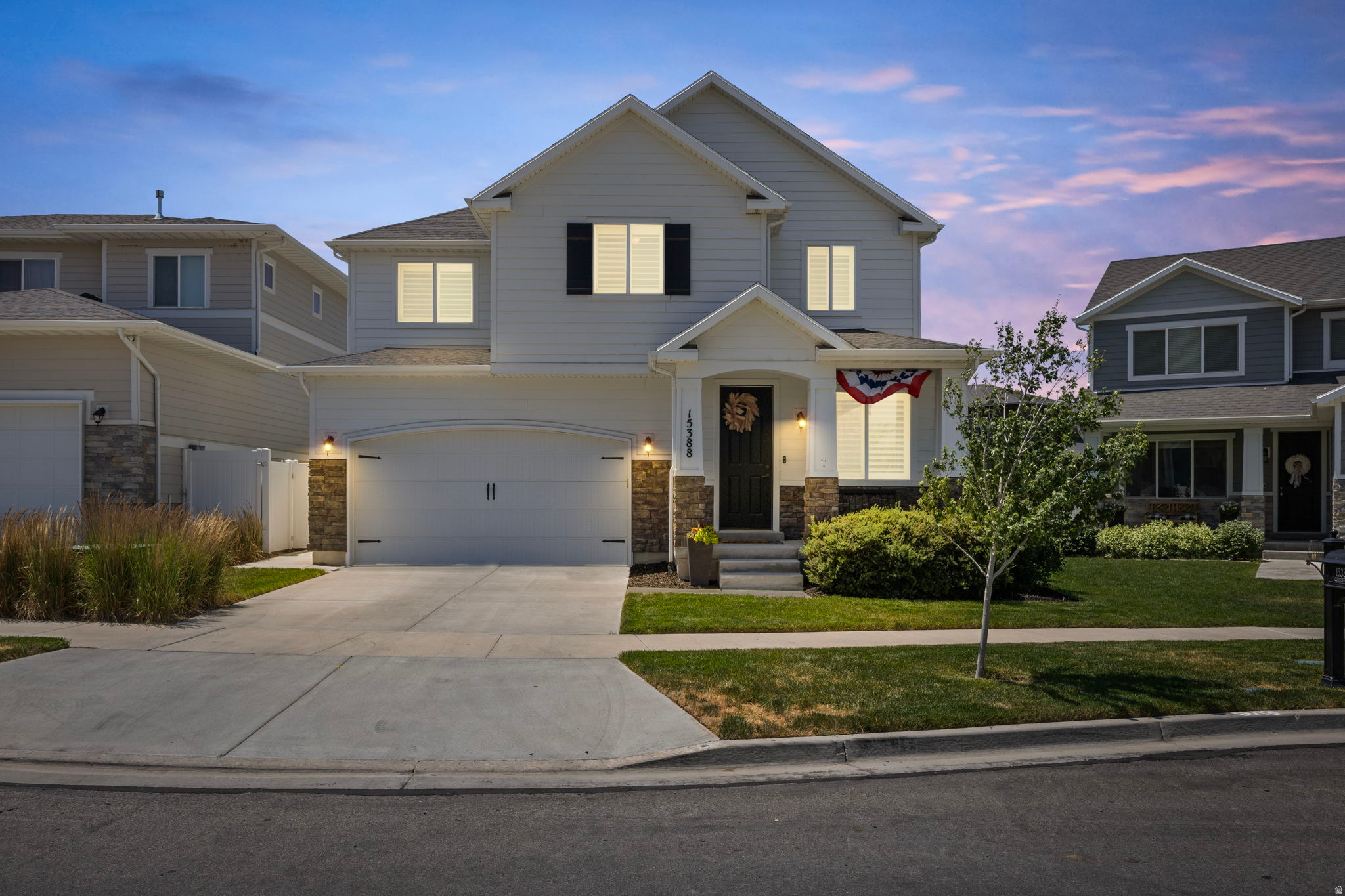 Contemporary two-story residence featuring a white siding exterior and dark shutters