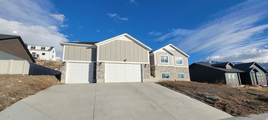 Located at 108 S 900 E in Hyde Park, UT, this single-family home on the Hyde Park Bench offers expansive valley and mountain views.  Property Overview: Originally built in December 2022, the residence features 3 bedrooms and 2 full bathrooms on the main level, maintaining an "almost new" feel.  Expansion Potential: The home includes an almost finished basement pre-plumbed for a 3rd bathroom, with space for two mostly finished bedrooms and a large storage area. Garage & Storage: A standout feature is the tandem garage with extra high ceilings, providing total parking for 4 vehicles. The space is designed to accommodate boats, UTVs, or an exercise room.