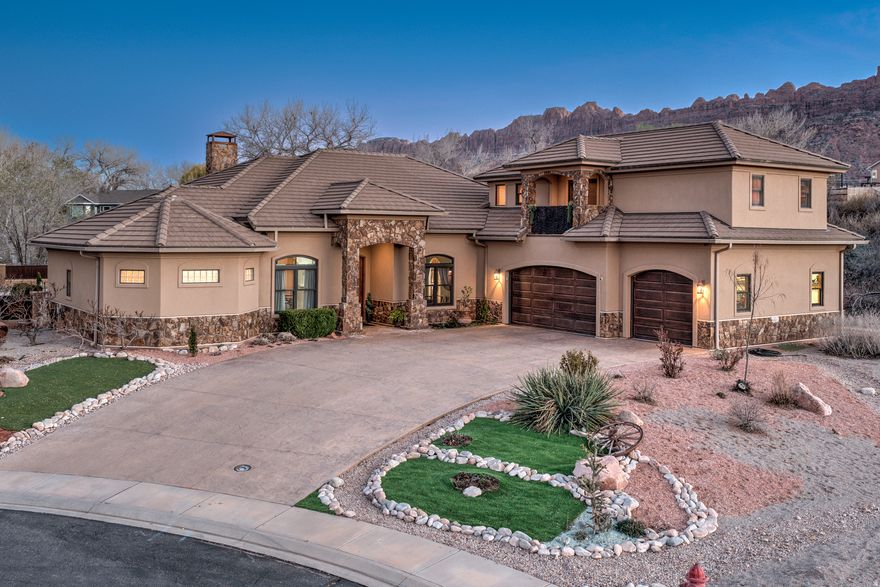 PRIVATE GEM- Hidden away in a private cul-de-sac, this luxurious gem sits under a forested canopy of Fremont Cottonwood trees alongside 7 acres of Pack Creek common area open space. Thoughtfully designed by a professional builder, the floor plan balances everyday living with comfortable entertaining. The front foyer opens into a bright, open concept living area with seamless flow throughout the main level with variety of flexible spaces for fine dining, lounging, separate creative workspace or a private gym. At the heart of the home, an expansive kitchen designed for both function and gathering offering ample counter space, a breakfast bar, and an additional bistro nook, all opening to a large family room filled with natural light and surrounding views. The generous remote primary suite features direct patio access, two large walk-in closets, a spacious travertine en suite bathroom complete with dual vanities, a walk-through shower, and an oversized soaking tub. Completing the main level is a guest room with en suite bath and two additional bedrooms with shared bath. The upper level has the best game parlor with a dry bar, balcony and half bath; a versatile room making it an ideal space for recreation, guests or a theater room. Ready to go outside?  Here you will enjoy a covered lanai with outdoor kitchen, bar seating, shaded lounge area, gas fire pit- and an in-ground heated pool with electric cover!  All capturing the sweeping views and a sense of quiet that is increasingly hard to find. Additional features include in-floor radiant heat, granite counters, hardwood floors, clay walls, a spacious 3-car garage with heated floors, heated driveway and side-yard RV parking.  This property offers a rare combination of location, layout, and livability, well-suited for those seeking space, privacy, and views without compromise, just a golf-cart ride away from Moab Golf Club.