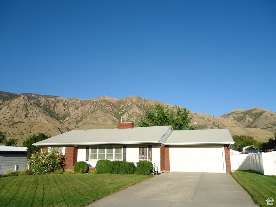 Welcome Home to this immaculate and spacious (app. 2,856 sq. ft.) 4-bedroom, 3-bath custom built rambler in NE Brigham City. The large .30 acre yard features a fun covered patio with a unique wood ceiling, a 6-foot privacy fence, full auto sprinklers, a circular clothesline, and an entrance to the basement. The view of the mountains is what the Seller says will be missed the most! The kitchen also has a custom wood ceiling and newer cabinets including a desk and large pantry cabinets. The spacious formal living room features a two-way fireplace surrounded by custom built-in bookcases. There are laundry hookups on both the main floor and in the basement. The large family room downstairs features a fireplace and a wet-bar for fun entertaining. There's plenty of storage space with all the shelving in the utility room. There are many updates including a newer front door, sliding glass door, and garage door, upgraded electrical on the main floor with 3-prong/grounded outlets, and newer double-pane windows except in the storage room. The listing agent represents the seller only, so please call your favorite agent to see this beautiful home.