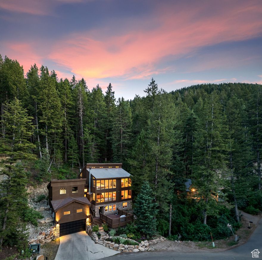 Perched among the evergreens in Summit Park, this 3-bedroom, 2-bathroom mountain retreat feels like a modern treehouse, immersed in nature yet just minutes from world-class Park City skiing and a quick drive to Salt Lake City via I-80. Spanning 2,650 square feet on nearly half an acre, the home offers a rare combination of alpine seclusion, dramatic views, and thoughtful design.  Expansive windows bring the forest inside, flooding the home with natural light and framing serene views from nearly every room. The main level features hardwood floors, an open-concept living area with a wood-burning fireplace, and a beautifully updated kitchen with granite countertops, stainless steel appliances, and a Viking range - ideal for mountain mornings and cozy evenings. A guest suite and full bathroom complete the main level.  Upstairs, the primary suite is a peaceful sanctuary with treetop views and a spa-like bath with a soaking tub. Another guest bedroom and a stunning office and library with expansive windows provide flexible space for work or relaxation, all under vaulted ceilings that enhance the sense of openness and light.  The lower level walkout includes a family room with surround sound and a projector, perfect for movie nights or entertaining, plus a spacious laundry and storage area. Two expansive decks invite you to enjoy summer evenings, morning coffee, and everything in between.  A 400-square-foot unfinished flex space above the garage with plumbing and sewer already in place, offers potential for a guest suite, studio, or office.  Surrounded by evergreens and perched above it all, this home feels worlds away while being steps from the Park City trail system and just a short drive to year-round recreation. Quiet, private, and impeccably maintained - 485 Upper Evergreen is mountain living at its finest.