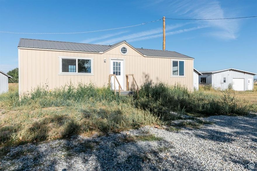 Over 4 Acres of Possibility! Escape the ordinary and embrace the potential of this 3-acre parcel. It features an insulated, wired, and plumbed unfinished tiny home with 1 bedroom and 1 bathroom-ready for your personal finishes.  A spacious 4-car detached garage offers ample room for vehicles, tools, or workshop needs. Additional sheds provide more storage.  Zoning allows for livestock, so bring chickens, goats, horses and cows. The flat, terrain makes expansion easy, whether you're planning gardens, fencing, or future structures. Located just minutes from town, this property blends convenience with wide-open possibilities. Buyer will need to put in septic system but parcel has a Fairview Water Hookup and electric is already on the property.