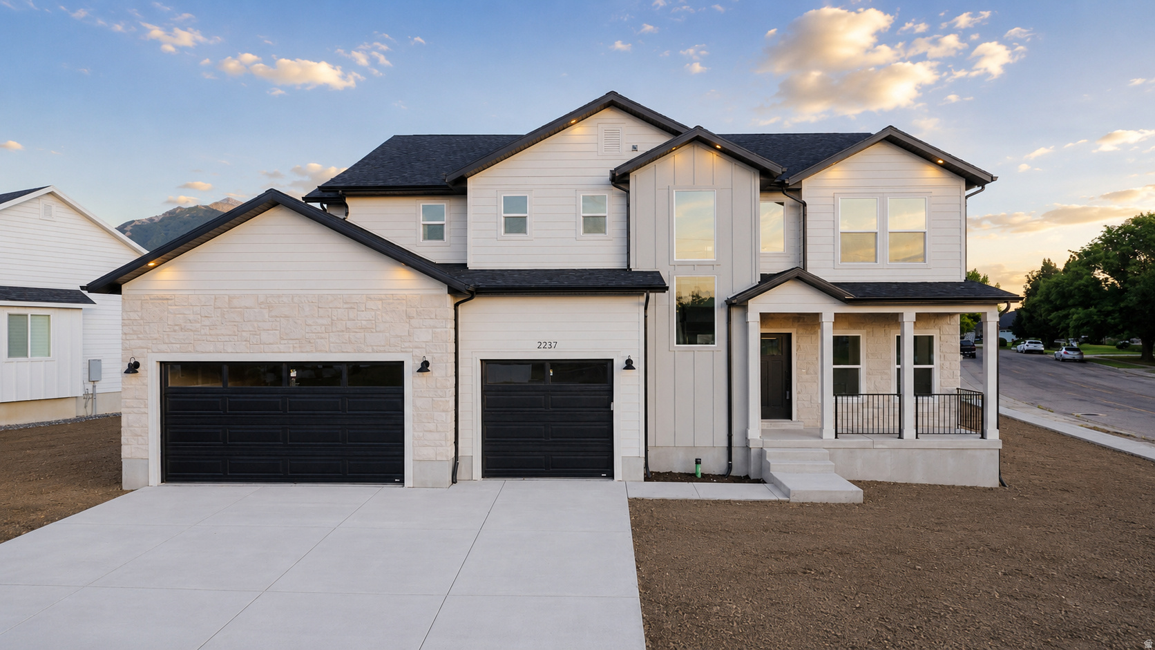 Contemporary two-story residence featuring light-colored siding and dark rooflines
