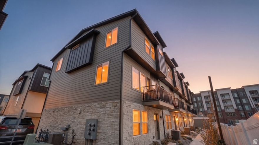Built in 2024, this light-filled 4-bedroom, 2.5-bath END-unit townhome offers modern design, thoughtful upgrades, and exceptional convenience in the heart of Midvale. Oversized windows flood all three levels with natural light, creating a bright and inviting atmosphere throughout. The open-concept kitchen is ideal for both entertaining and everyday living, featuring a gas range, 42" two-tone cabinetry, 3cm quartz countertops, a large island, and a walk-in pantry. The entire second floor, bathrooms & laundry room showcase durable luxury vinyl plank flooring, complemented by upgraded carpet elsewhere. Enjoy the spacious living room with direct access to a private balcony, complete with a gas line for BBQ. The main-level bedroom offers flexible space perfect for a home office, gym, or media room & includes a dedicated fiber optic line run directly to the garage. HOA-covered fiber internet adds built-in convenience. Upstairs, the primary suite features a walk-in closet, large walk-in shower, double vanity, and upgraded black plumbing fixtures. Two additional bedrooms, a full bath, and a dedicated laundry room complete the upper level. Additional highlights include end-unit privacy with extra natural light, an epoxy-coated 2-car garage floor, smart belt-drive garage door opener with keypad, water recirculation system (no waiting for hot water) & quartz countertops throughout. Enjoy a gated community dog area and an unbeatable location-walking distance to TRAX for easy commuting. Just 2 miles from Gardner Village, Fashion Place Mall, and Bingham Junction (WinCo, Topgolf, and dining), under half a mile to Midvale City Park, and only minutes from historic downtown Midvale. No rental restrictions. Community guest parking. Square footage as per four previous listings, buyer to verify.