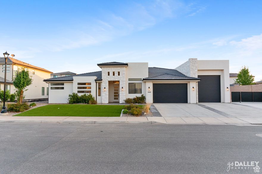 Located in Little Valley, Desert Hills boundaries, this 3,175 sq ft home built in 2021 includes 5 bedrooms/office, 2.5 baths, an RV garage, and side yard parking with a cement pad and iron gate. The yard is fully landscaped with turf for low maintenance. Inside is an open layout with tall ceilings and a functional kitchen. The primary suite includes a walk-in closet, a soaking tub, and a separate glass double shower. The home is on Dixie Power (low power bills) and is within walking distance to the park and the best sourdough bakery in Southern Utah. It is conveniently located near shopping, medical facilities, golf courses, hiking trails, biking paths, national parks, and approximately 22 minutes from Sand Hollow Reservoir.