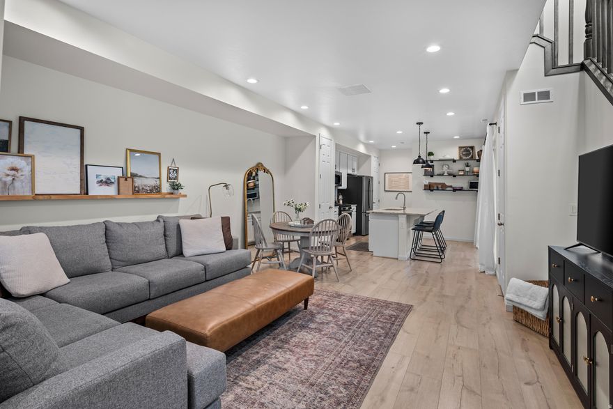 Beautifully upgraded twin home offering the perfect blend of style, functionality, and convenience with only one shared wall and an abundance of natural light throughout. The open-concept main level is designed for modern living and entertaining, featuring durable LVP flooring in a warm Sand Pearl Oak finish and a seamless flow between the living, dining, and kitchen spaces. The kitchen is a standout with white cabinetry, granite countertops, stainless steel appliances including a gas oven, dishwasher, and microwave, plus elegant pendant lighting over the island. Extra-tall 8-foot doorways enhance the sense of space, while the upgraded stair railing with a rich midnight black stain adds a custom, high-end touch. Upstairs, the primary suite offers thoughtful upgrades including additional windows for natural light, a raised 7 foot showerhead, comfort-height toilet, and custom closet shelving. Ceiling fans in all three bedrooms provide added comfort year round. This home is packed with modern conveniences, including Cat6 Ethernet wiring throughout, smart home features (doorbell, lock, thermostat, and garage opener), and access to high speed fiber internet. Enjoy efficiency and comfort with your own tankless water heater and water softener. The garage is equally impressive with an extended landing area perfect for larger vehicles or extra storage plus three heavy duty ceiling mounted racks (each 3'x6' with 600 lb capacity). Located just minutes from freeway access, this home offers an unbeatable combination of upgraded living and everyday convenience